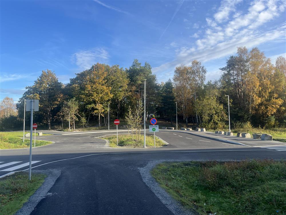 Dropsonen i Holvika, asfalt, skilt og trær - Klikk for stort bilde