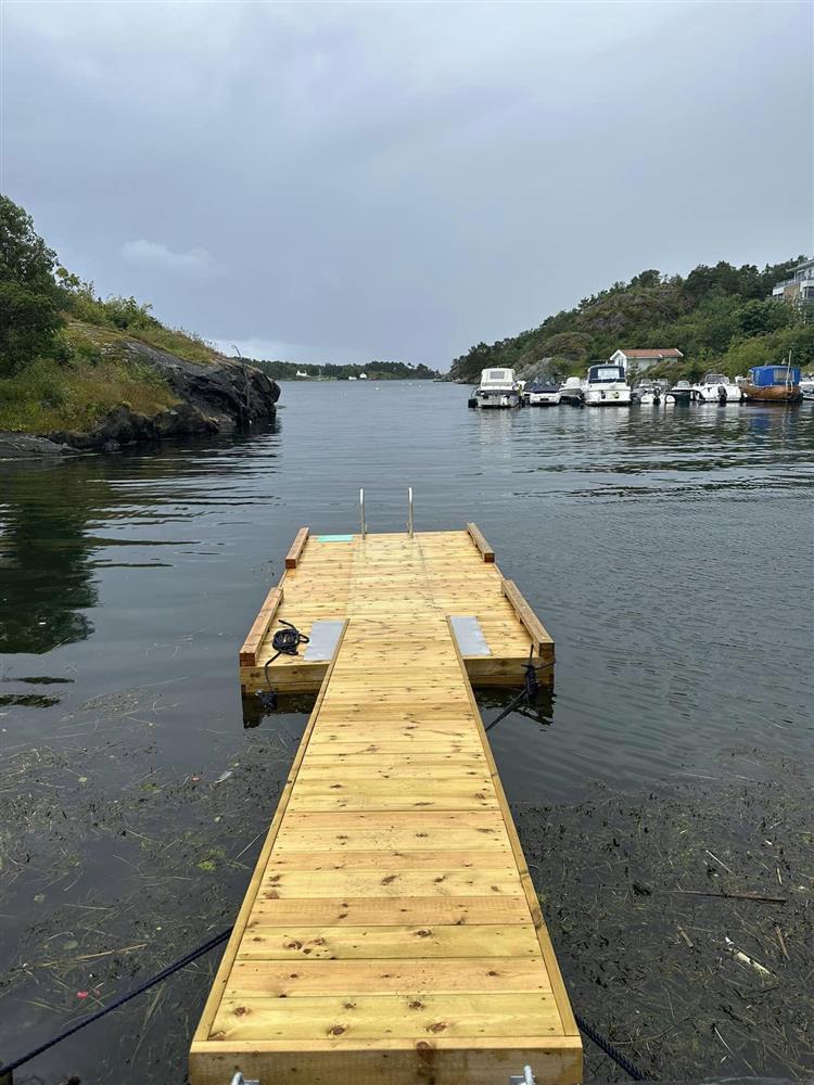 Flytebrygge av tre ligger på vannet - Klikk for stort bilde