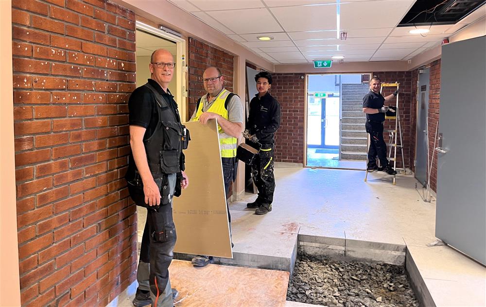 Arbeidere jobber på i en stor gang - Klikk for stort bilde