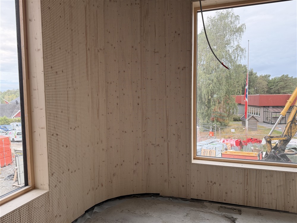 Et rom med perforerte akustikkplater og vinduer. - Klikk for stort bilde