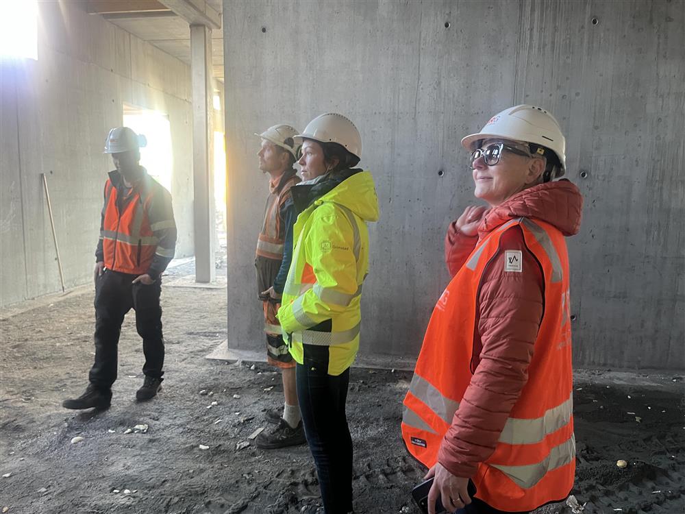 Fire mennesker inne i et område med betongvegger. - Klikk for stort bilde