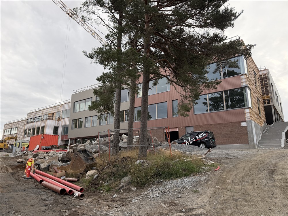 Et bygg under oppføring og noen trær. - Klikk for stort bilde