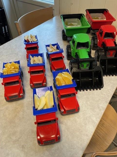 Små lekelastebiler fylt med frukt - Klikk for stort bilde