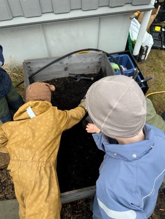 Ryggen på to barn som sår i en kasse - Klikk for stort bilde